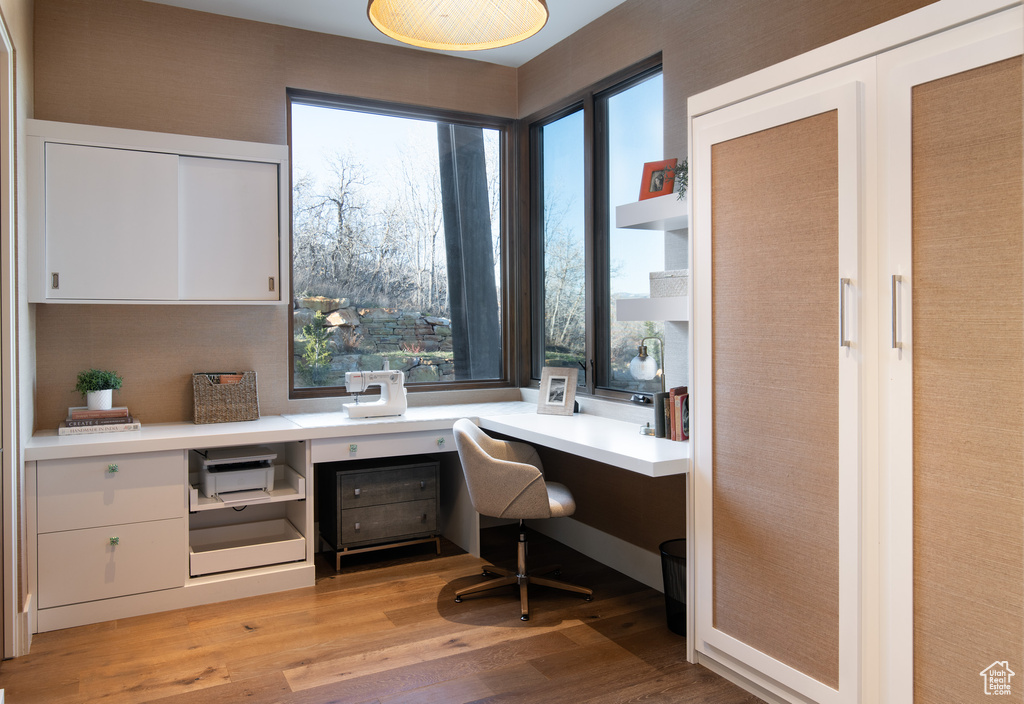 Home office featuring built in study area and light wood-style flooring
