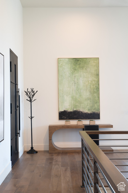 Corridor featuring dark wood-style floors and baseboards