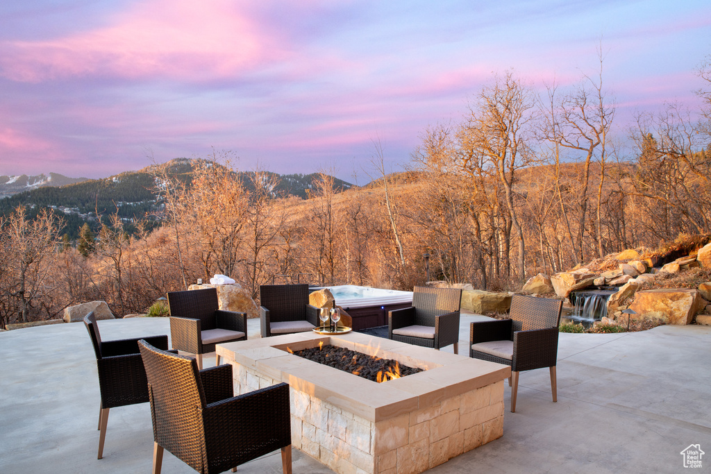Patio terrace at dusk with a fire pit and a mountain view