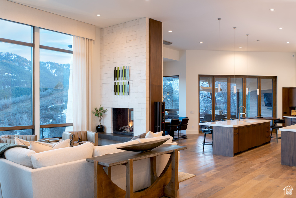 Living area featuring a mountain view, a fireplace, light wood-type flooring, healthy amount of natural light, and recessed lighting