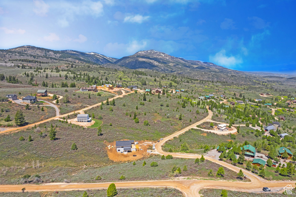 Aerial view of property and surrounding area featuring a mountain backdrop and rural landscape