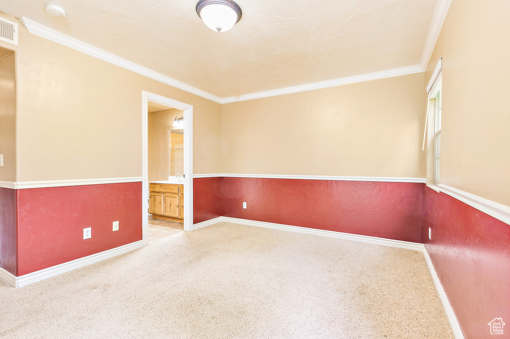 Unfurnished room featuring baseboards, ornamental molding, and a smoke detector