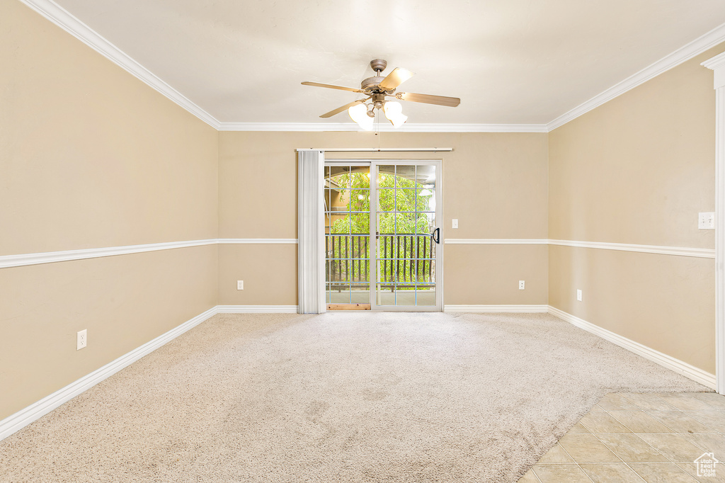 Carpeted spare room featuring a ceiling fan, ornamental molding, and baseboards