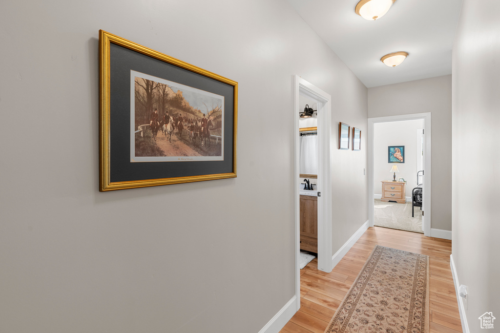 Hallway featuring light wood-style flooring and baseboards
