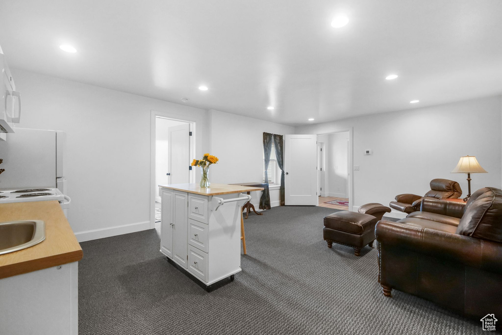 Living room with recessed lighting and dark colored carpet