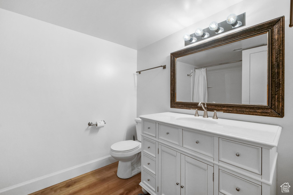 Full bath with wood finished floors, vanity, and a shower with shower curtain
