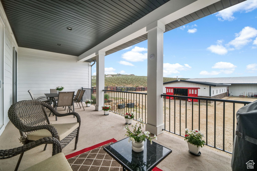 Balcony with outdoor dining space, a rural view, and grilling area