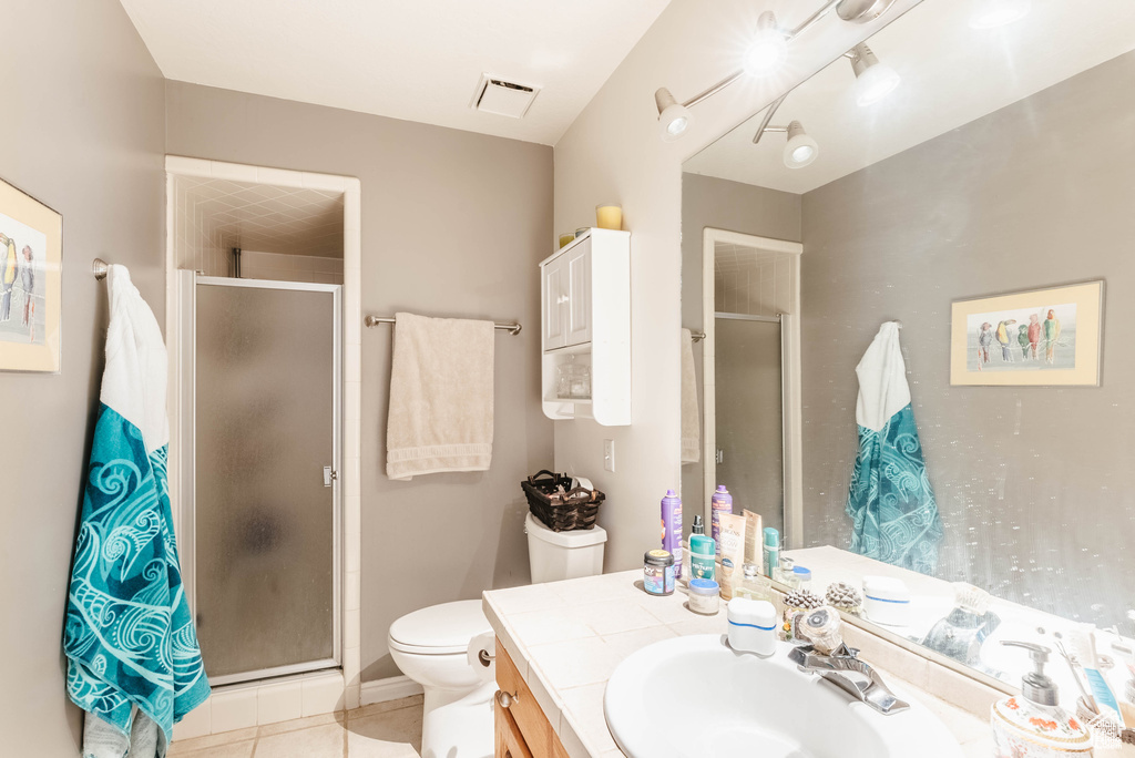 Full bath with a stall shower, tile patterned floors, toilet, and vanity