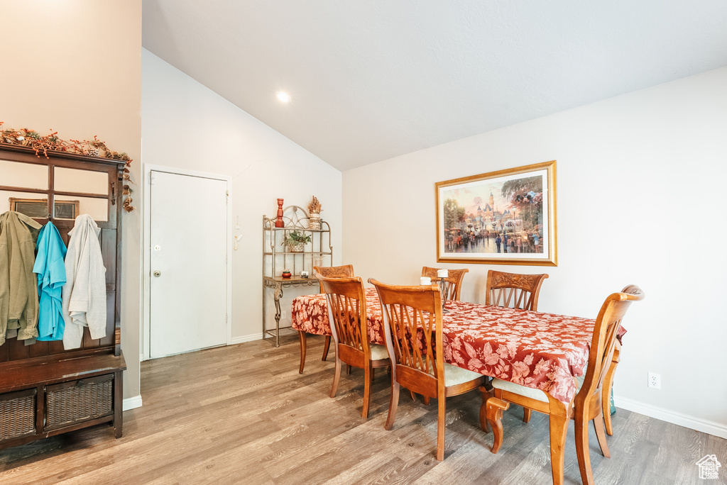 Dining space with vaulted ceiling, light wood-style flooring, and baseboards