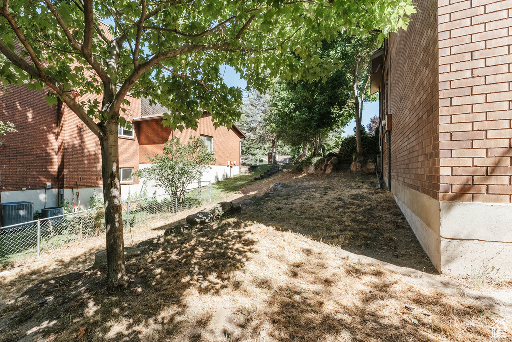 View of yard featuring fence and central air condition unit