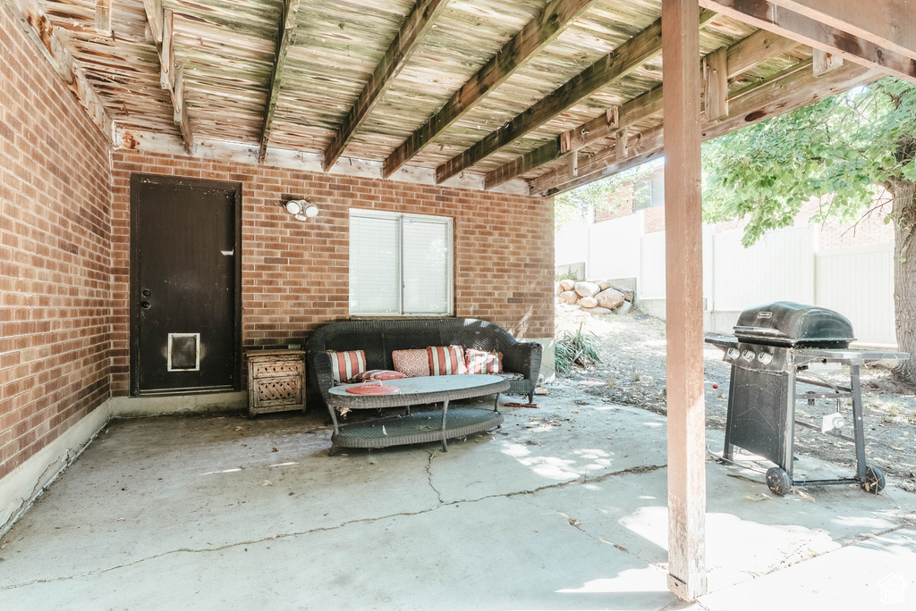View of patio with grilling area, fence, and an outdoor living space