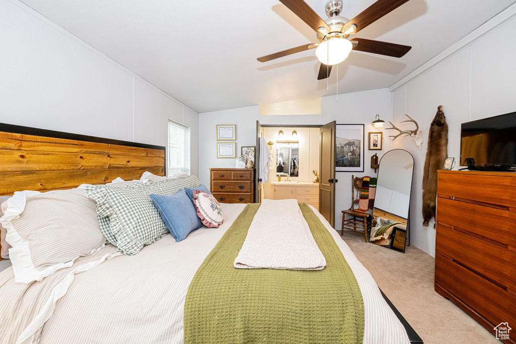 Bedroom with light colored carpet, connected bathroom, and ceiling fan