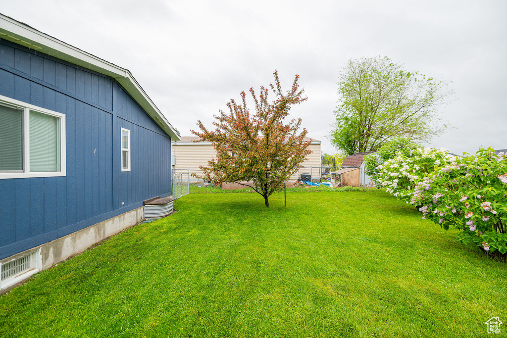 View of grassy yard with a storage unit and an outdoor structure