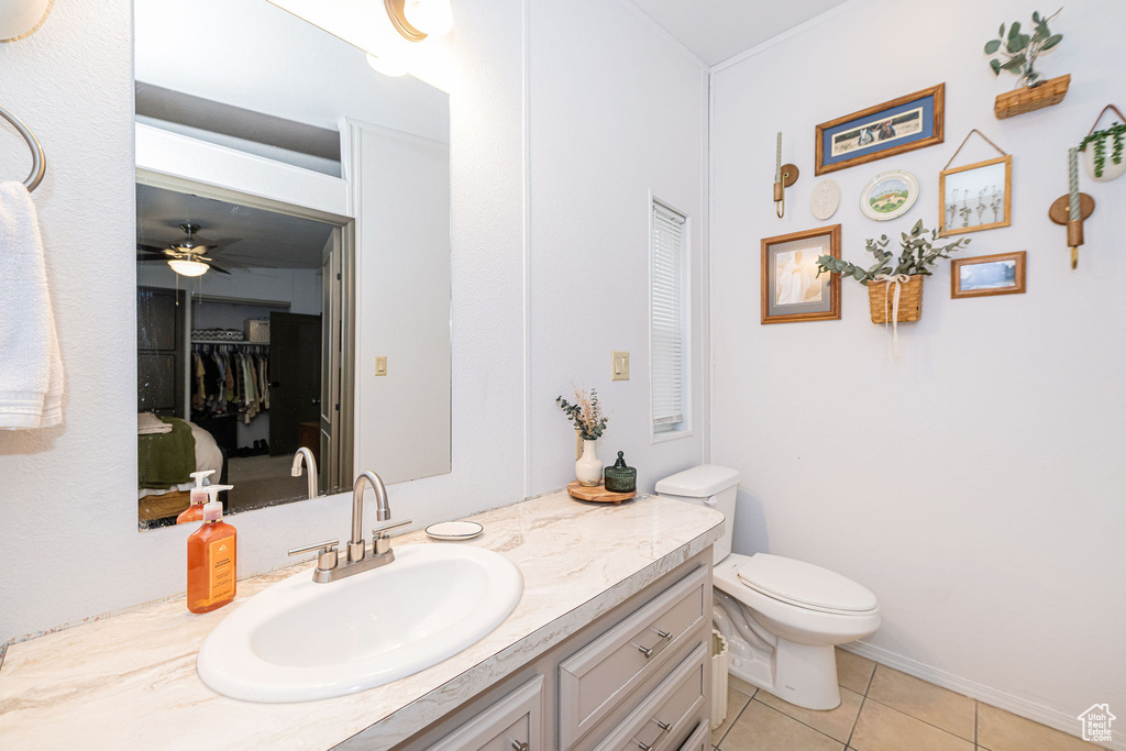Bathroom featuring tile patterned floors, vanity, toilet, and a ceiling fan