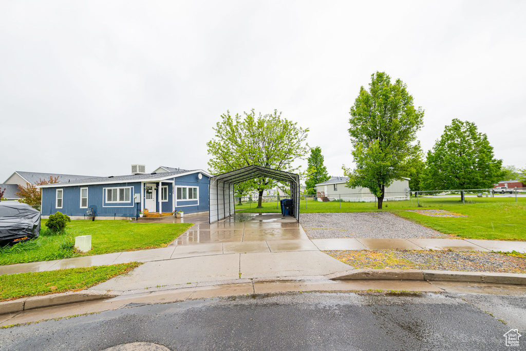 View of front of property featuring a carport and driveway