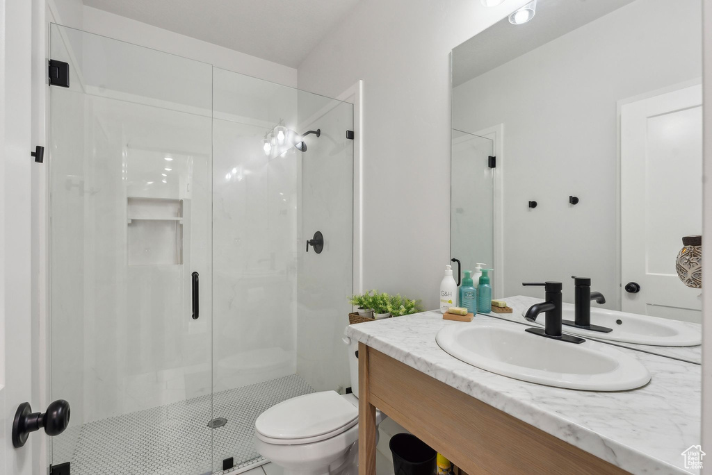 Full bath with a shower stall, toilet, and vanity