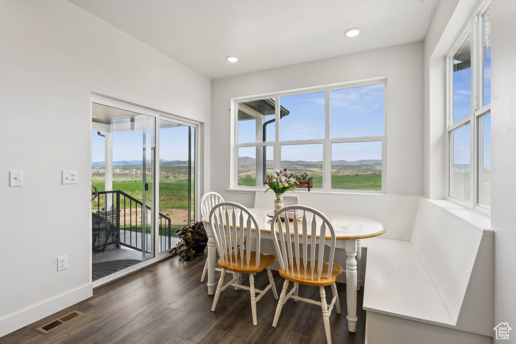 Dining room featuring dark wood-style flooring, recessed lighting, a mountain view, and baseboards