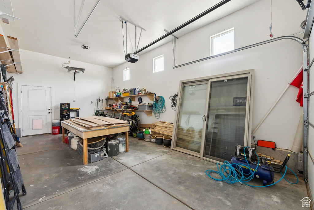 Garage featuring a garage door opener and a workshop area