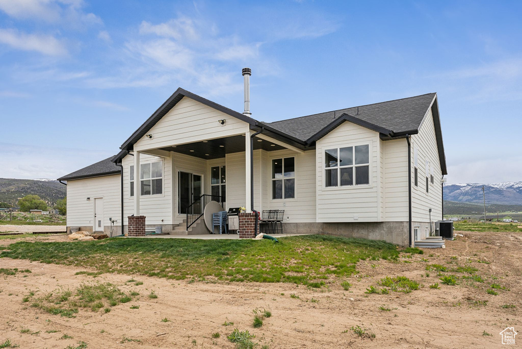 Rear view of house with cooling unit, a mountain view, entry steps, and a patio