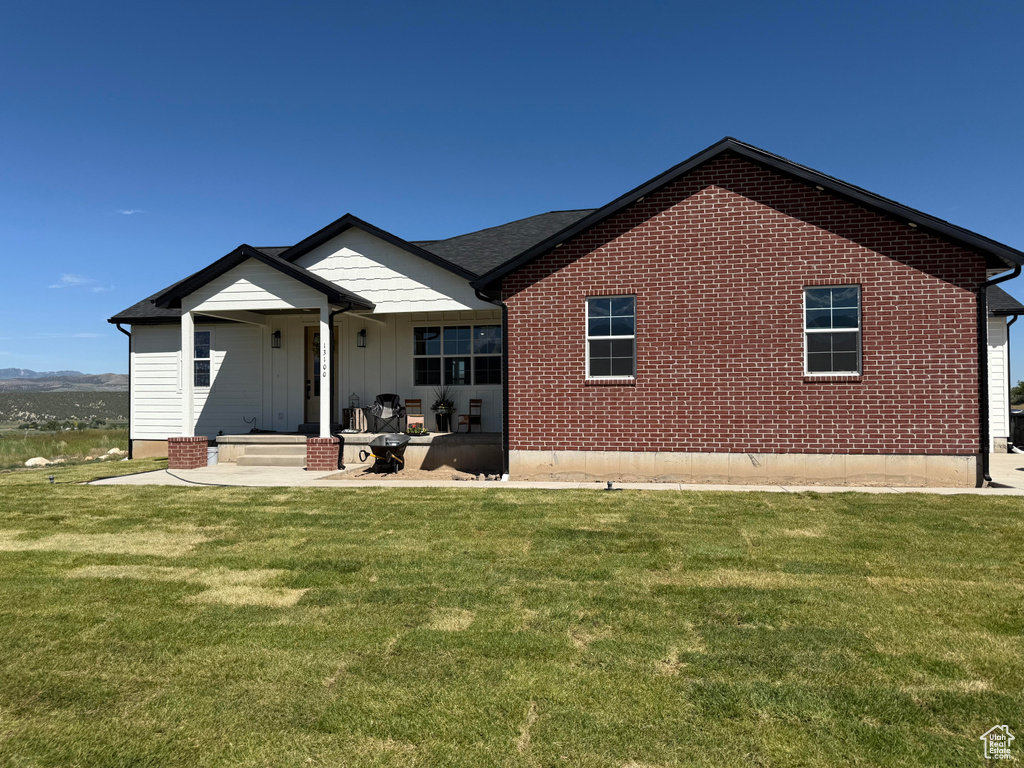 Back of property with a lawn