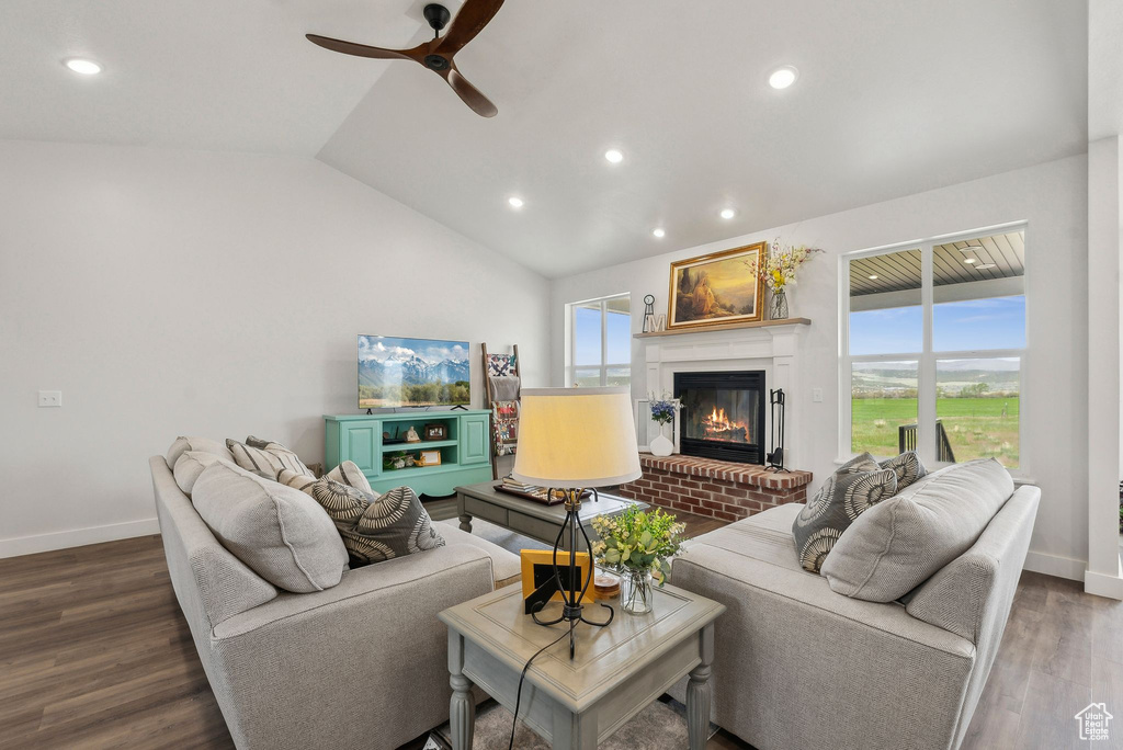 Living area with a brick fireplace, recessed lighting, wood finished floors, baseboards, and ceiling fan
