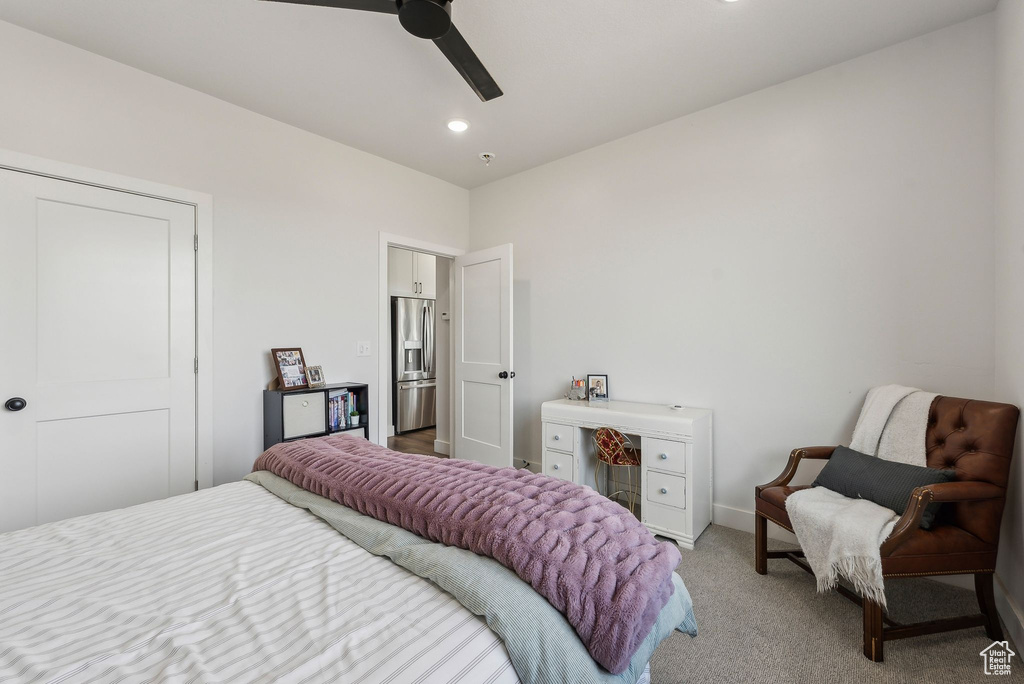Bedroom with stainless steel fridge, light colored carpet, baseboards, and ceiling fan