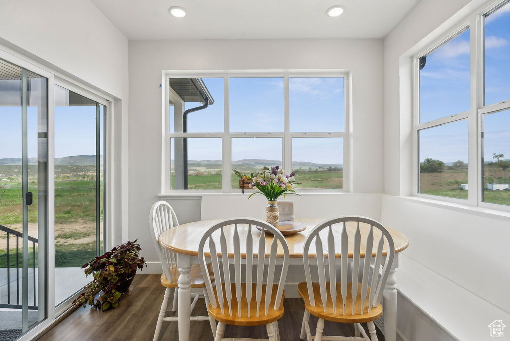 Dining space with plenty of natural light, dark wood-type flooring, a mountain view, and recessed lighting