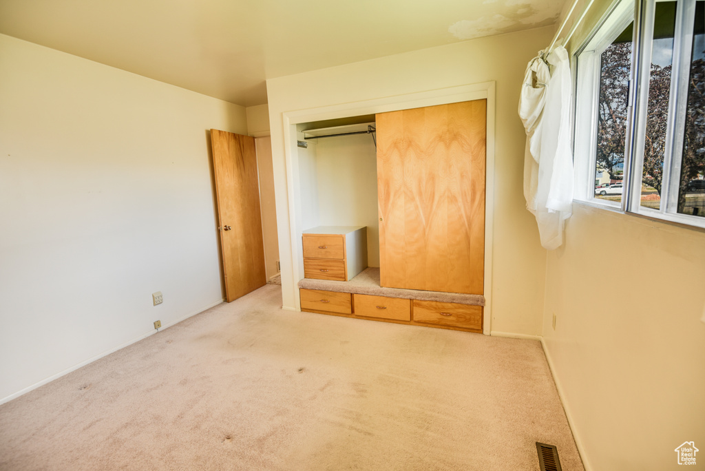 Unfurnished bedroom featuring carpet flooring and a closet