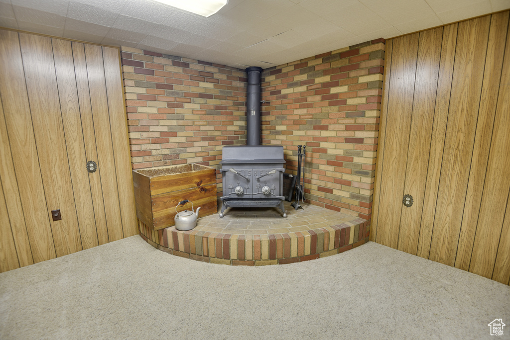 Detailed view of a wood stove, carpet floors, and wood walls