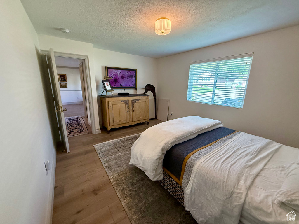 Bedroom featuring wood finished floors and a textured ceiling