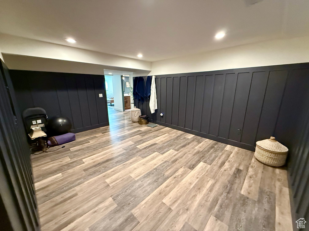Unfurnished room with light wood finished floors, a decorative wall, wainscoting, and recessed lighting