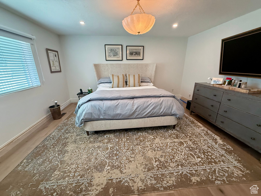 Bedroom featuring wood finished floors, baseboards, and recessed lighting