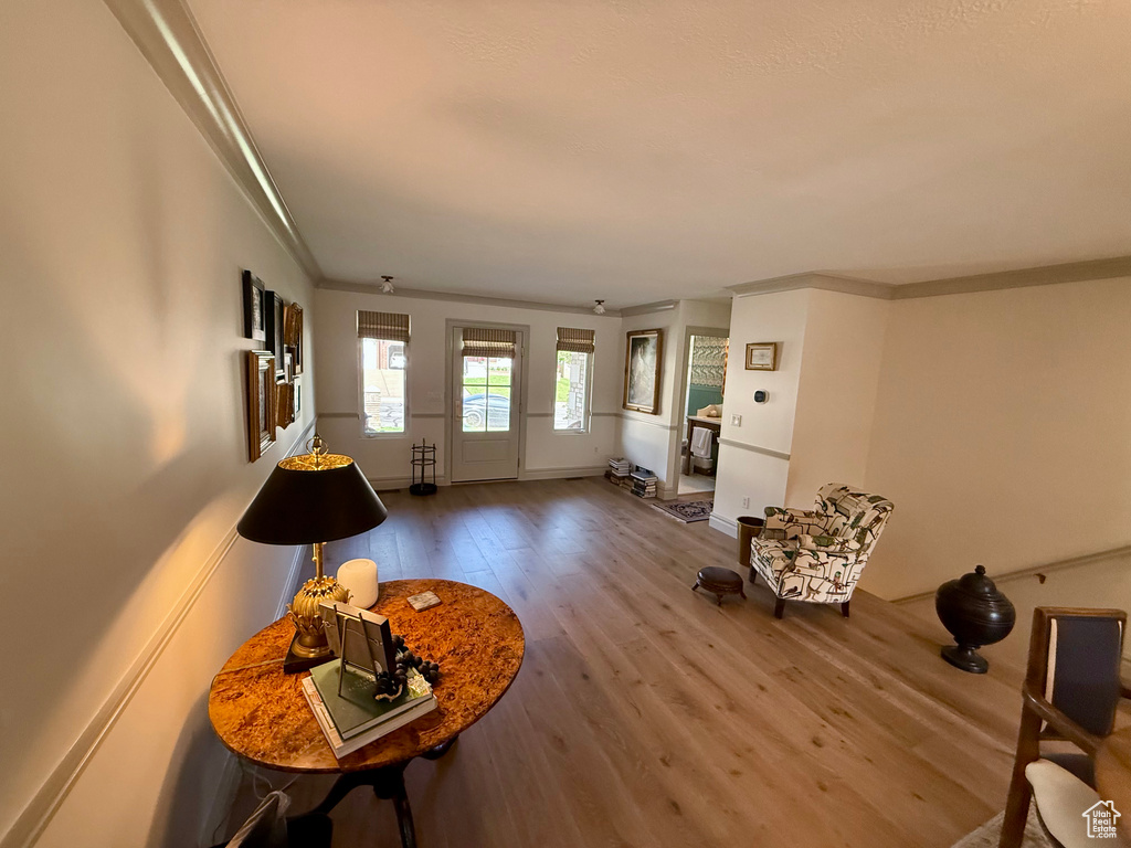 Living area featuring crown molding, wood finished floors, and baseboards