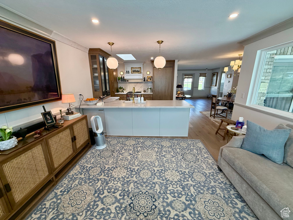 Kitchen with a peninsula, open floor plan, wood finished floors, pendant lighting, and recessed lighting