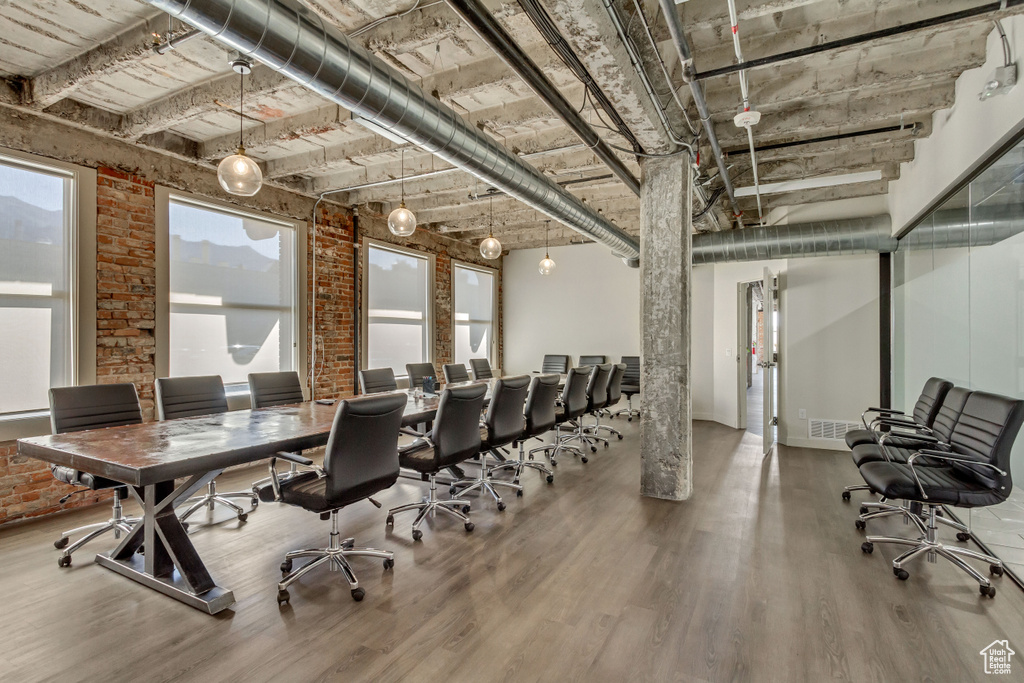 Home office with wood finished floors and brick wall