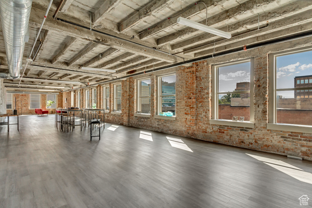 Miscellaneous room featuring brick wall and wood finished floors