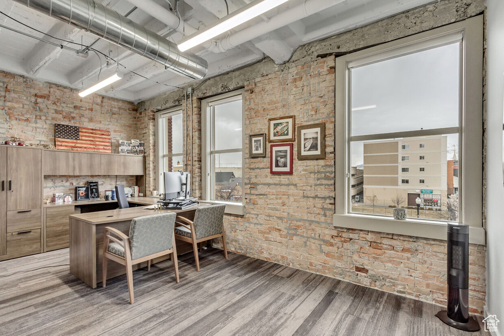 Office space featuring brick wall and light wood-style flooring
