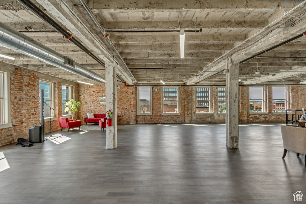 Basement with brick wall and wood finished floors