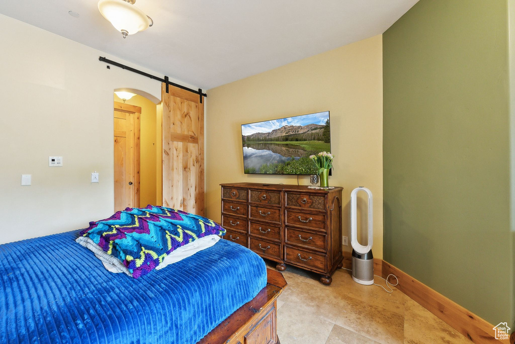 Bedroom with a barn door and baseboards