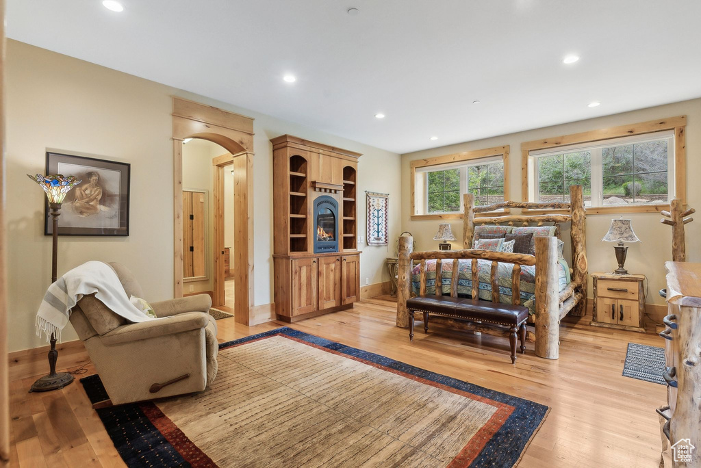 Bedroom featuring light wood finished floors, recessed lighting, baseboards, and arched walkways