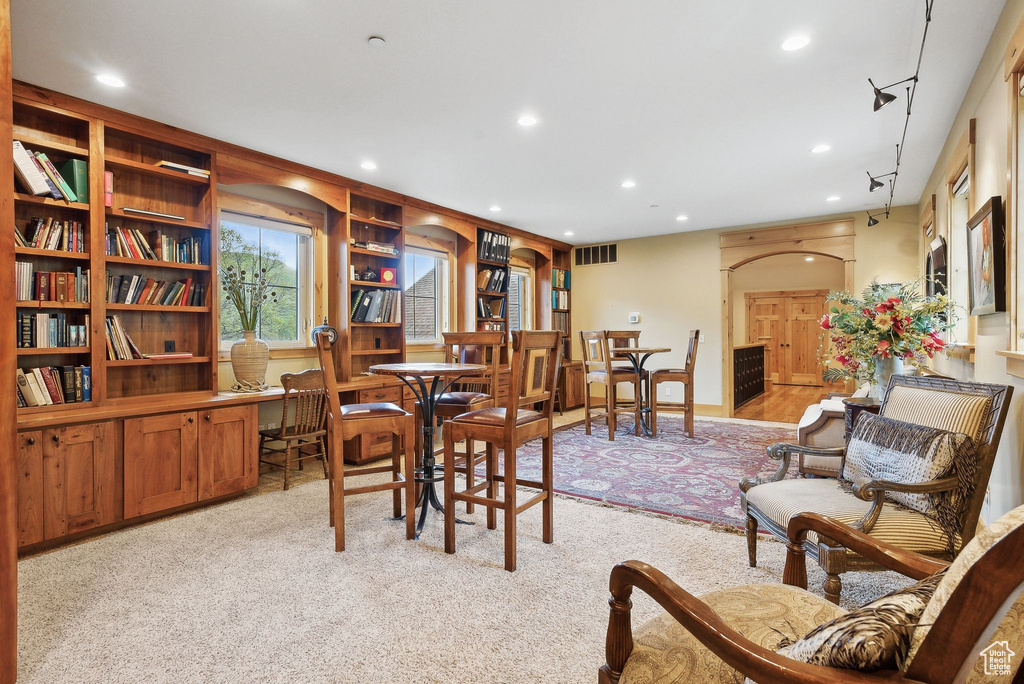 Dining space featuring light colored carpet and recessed lighting