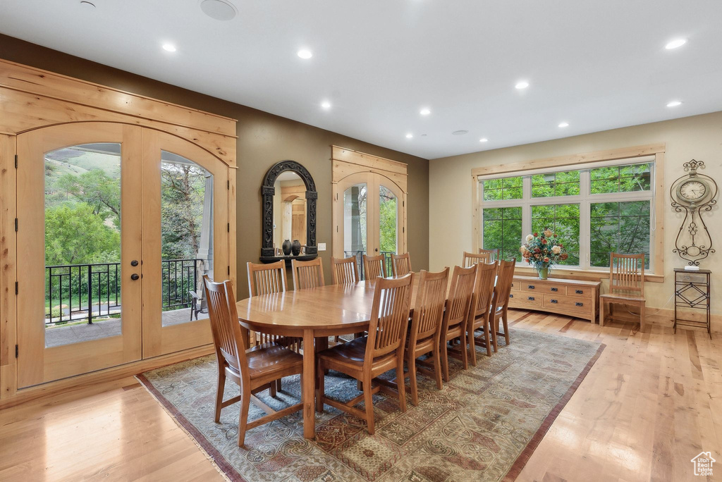 Dining space with french doors, recessed lighting, light wood-type flooring, and arched walkways