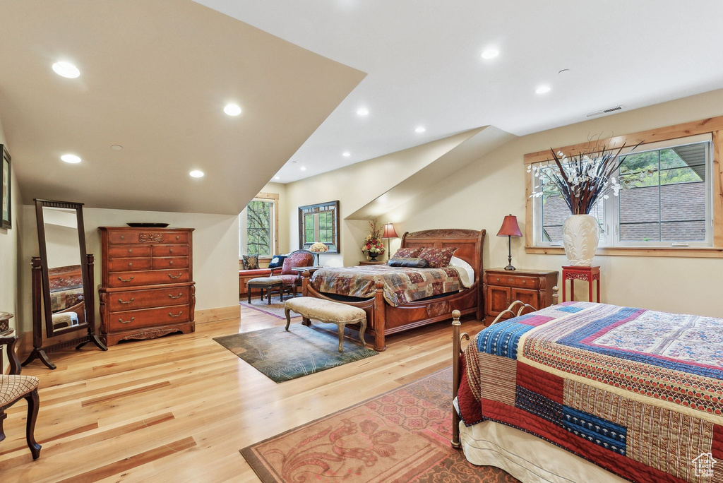 Bedroom featuring multiple windows, light wood-type flooring, and recessed lighting