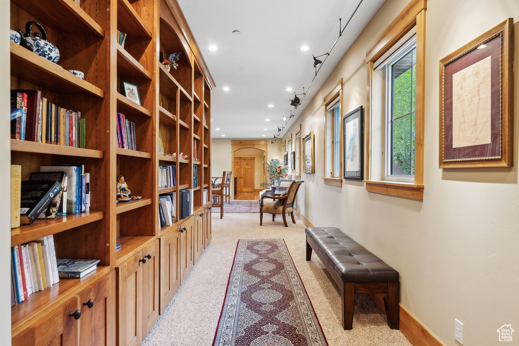 Hallway with arched walkways, light colored carpet, recessed lighting, and baseboards