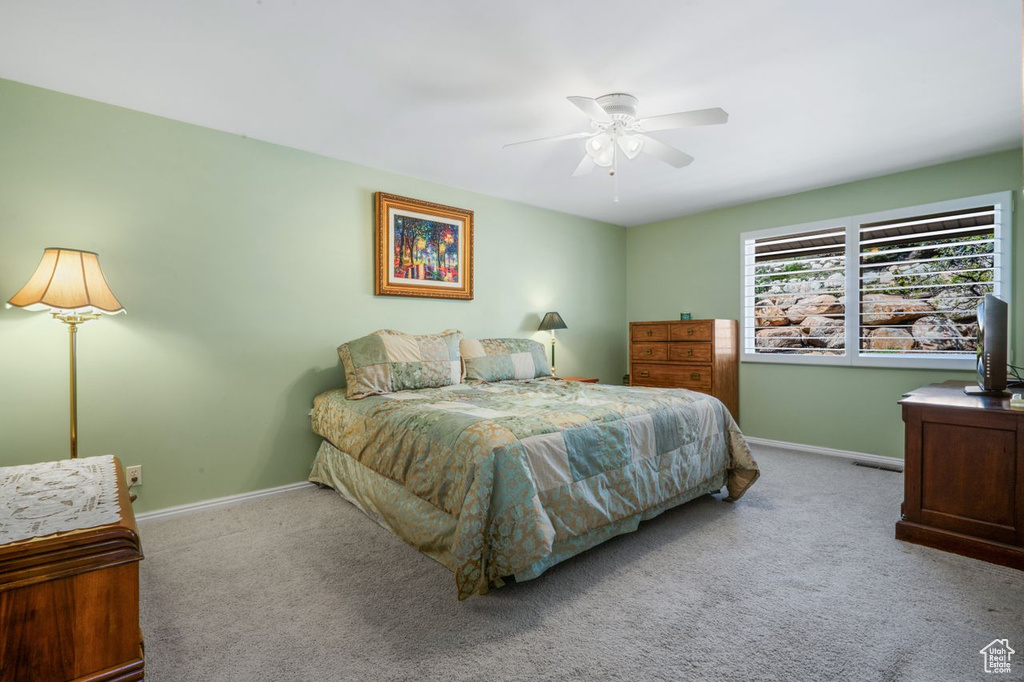 Carpeted bedroom with baseboards and a ceiling fan