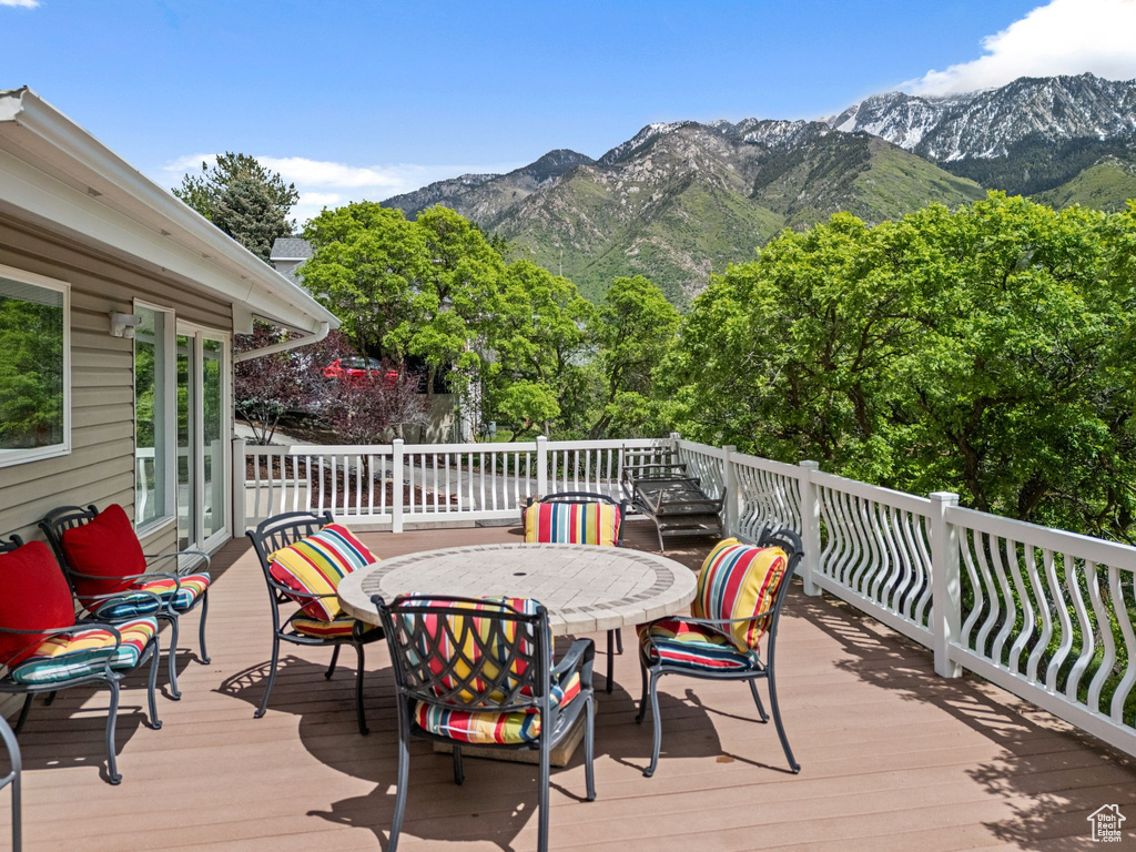 Wooden deck with a mountain view and outdoor dining space