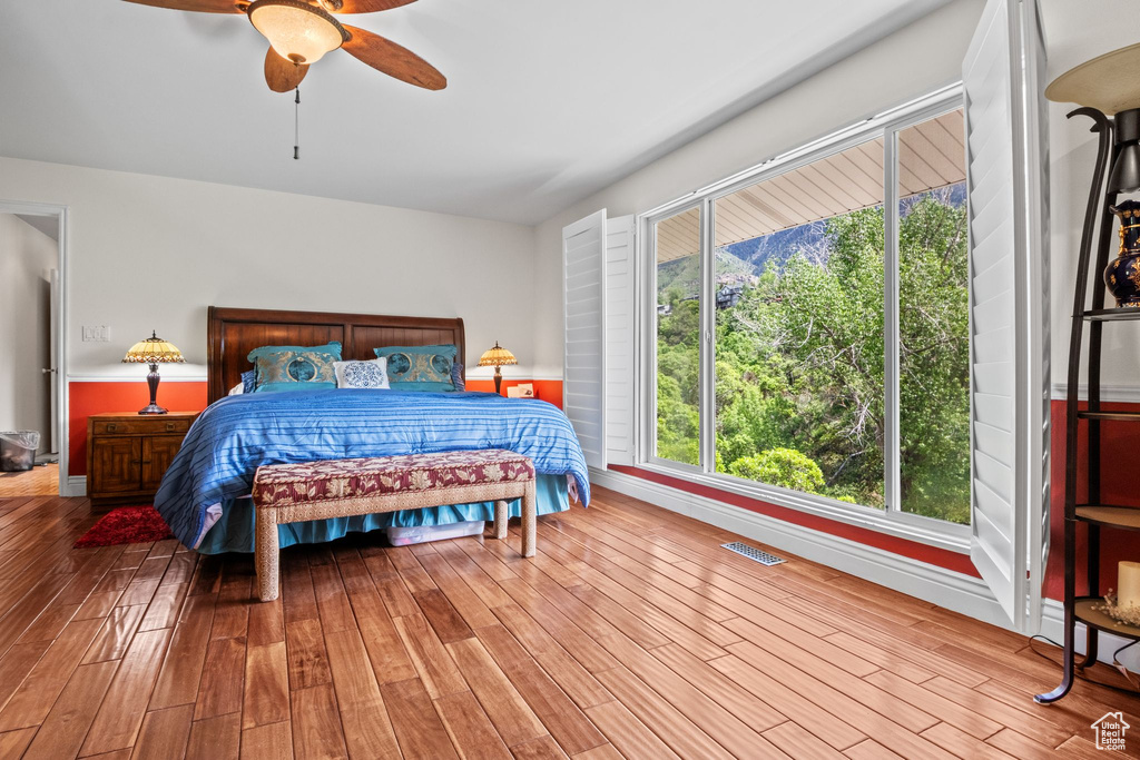 Bedroom with wood finished floors, a ceiling fan, and baseboards