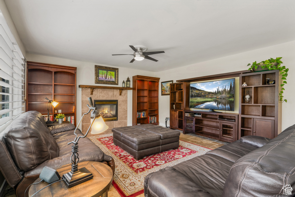 Living area featuring ceiling fan and a tiled fireplace