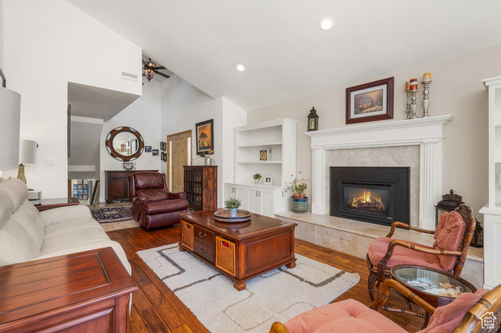 Living room featuring a fireplace, hardwood / wood-style floors, a ceiling fan, recessed lighting, and high vaulted ceiling