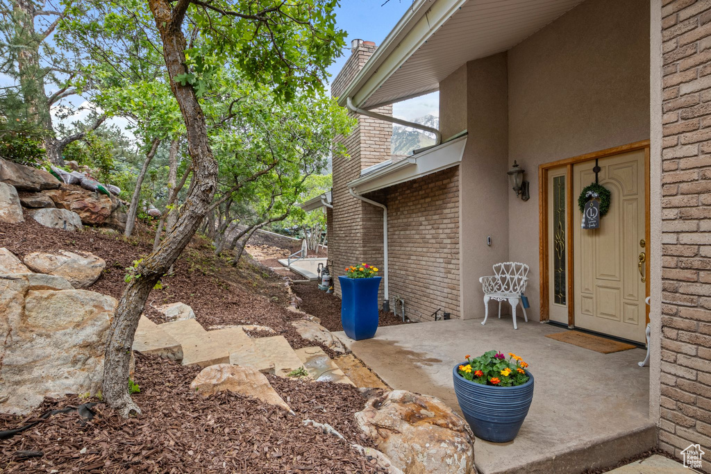 View of exterior entry featuring brick siding and stucco siding